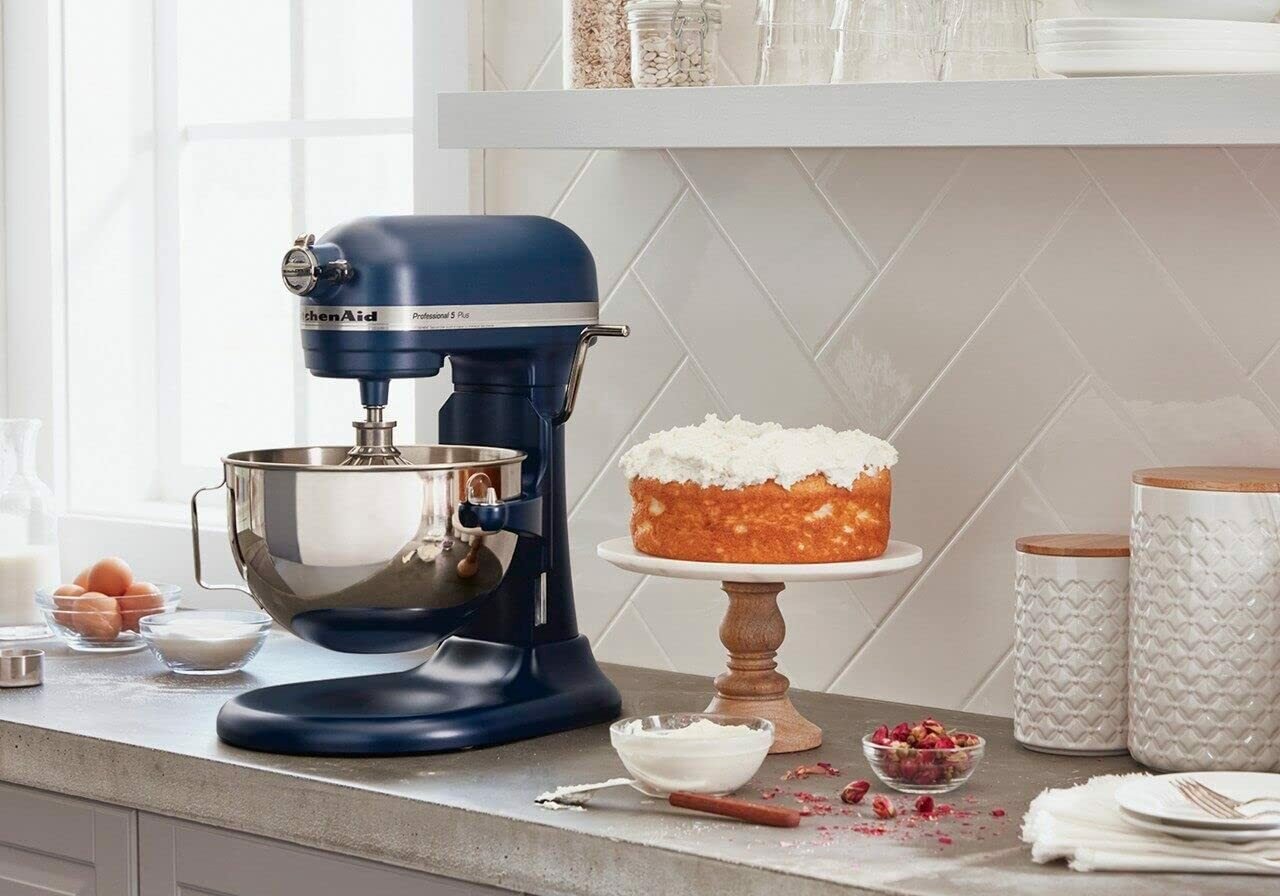Stand mixer on a counter next to a cake