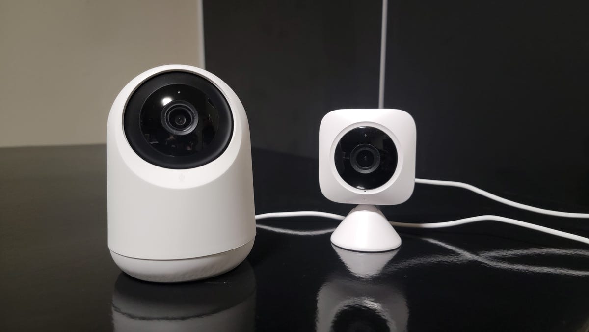 Two SwitchBot indoor cameras sitting on black table