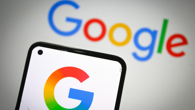 Google logo on smartphone with google written on white background