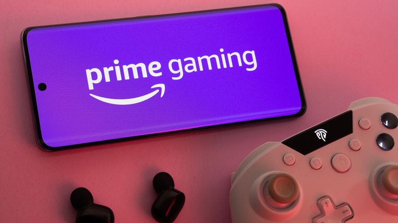 A smartphone displaying Prime Gaming logo alongside a controller and headphones