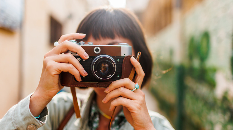 A woman photographing with a classic camera