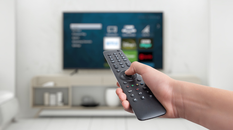 A person using a remote control on a smart TV.