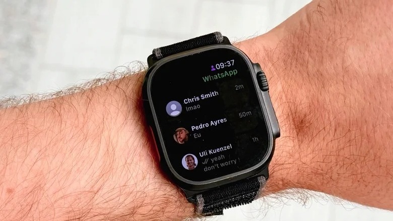 A person wearing an Apple Watch with WhatsApp app on the display