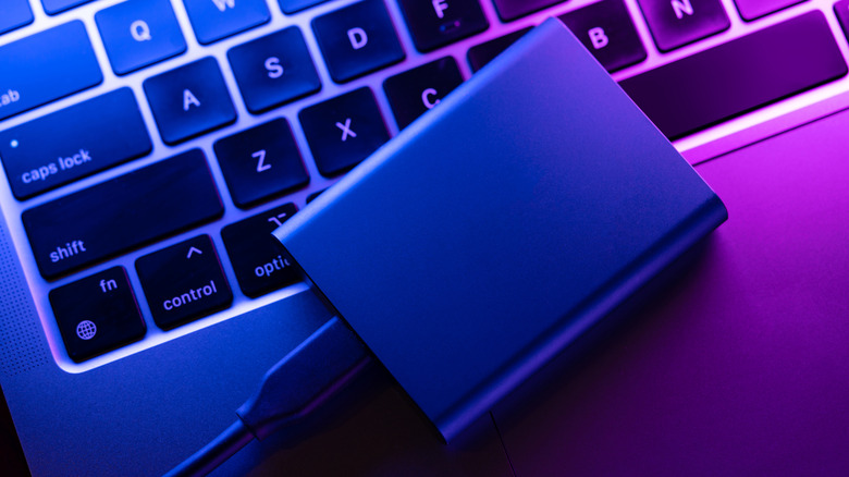 An SSD linked to a Macbook under neon illumination