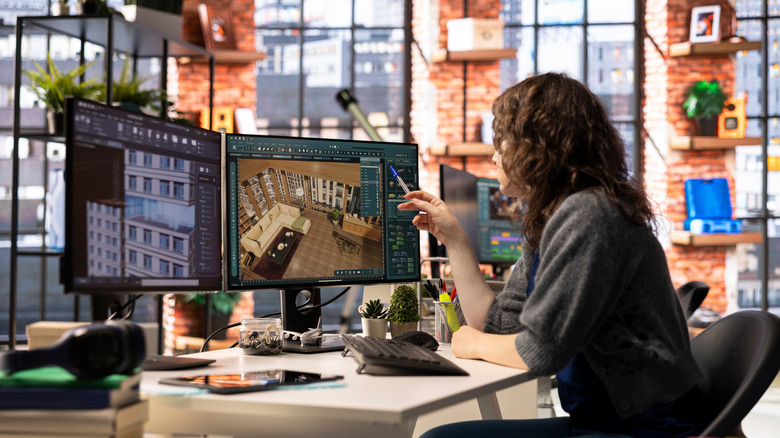 A digital designer utilizing dual monitors.