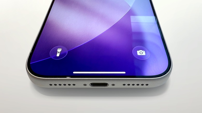 iPhone on a white table displaying flashlight and camera icons at the bottom of the screen