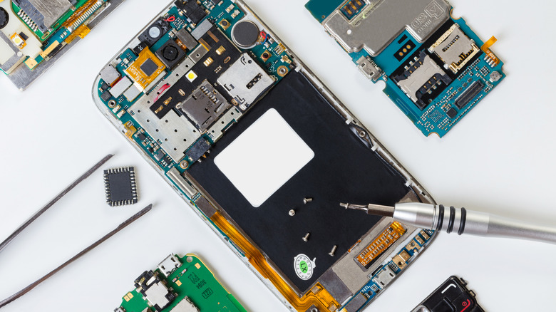 A smartphone undergoing repair is shown against a white background.