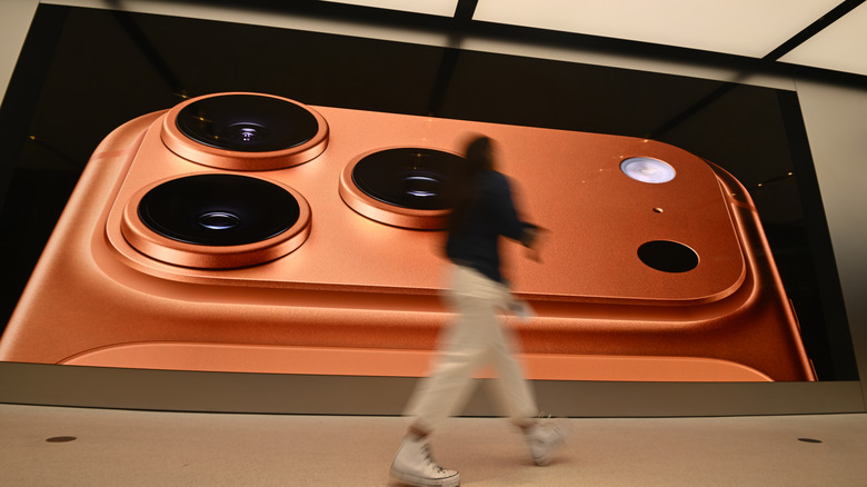 A person walking by an iPhone 17 billboard.