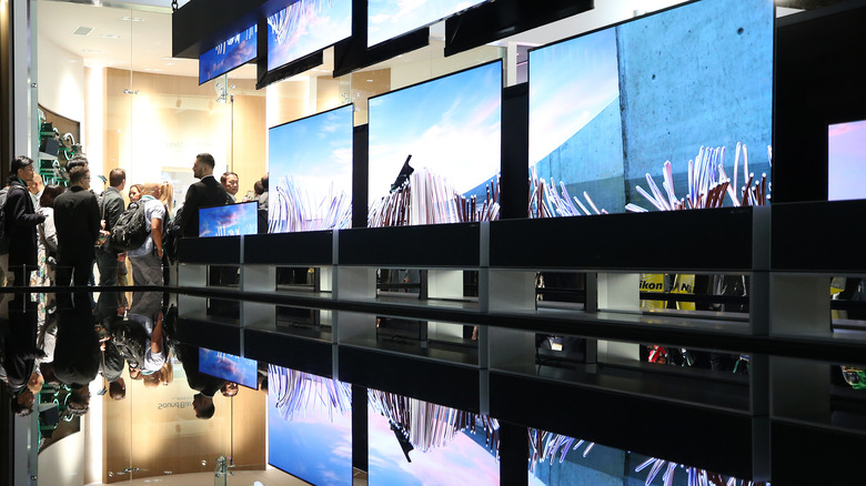 People viewing the LG Signature OLED R rollable televisions at the LG booth during CES 2020