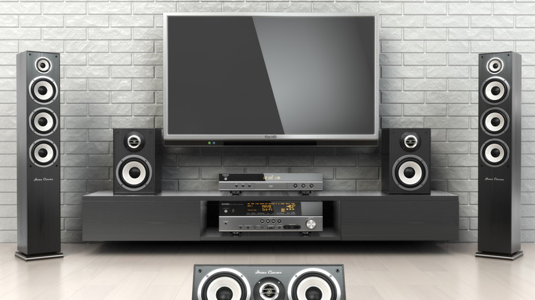 A TV surrounded by a large home theater setup.