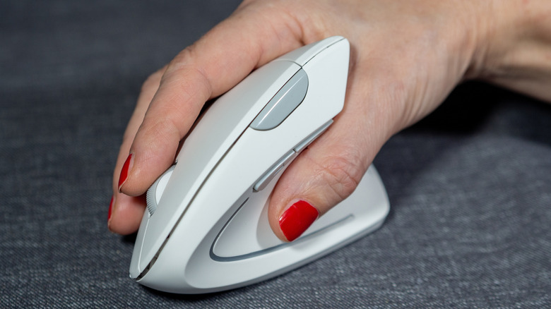 A hand resting on a vertical ergonomic mouse.