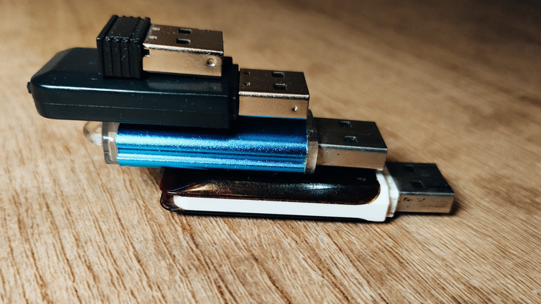 Several thumb drives and USB drives arranged on top of one another