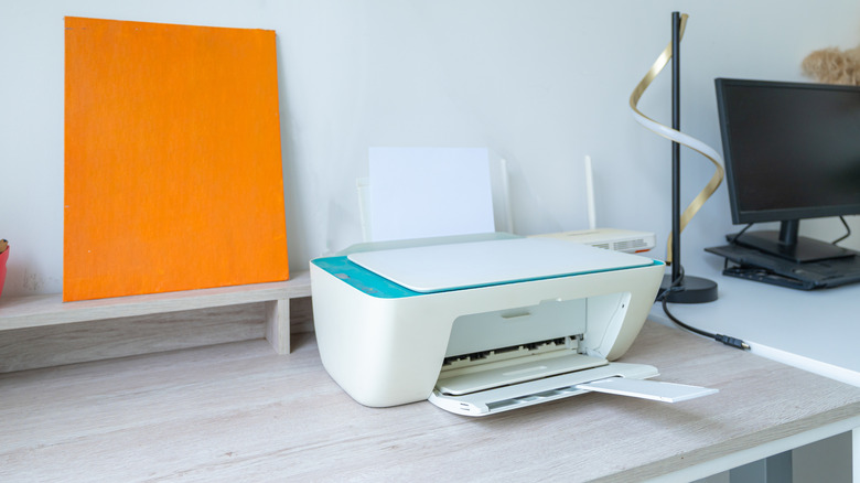 a workstation equipped with printer, router, and monitor on the desk
