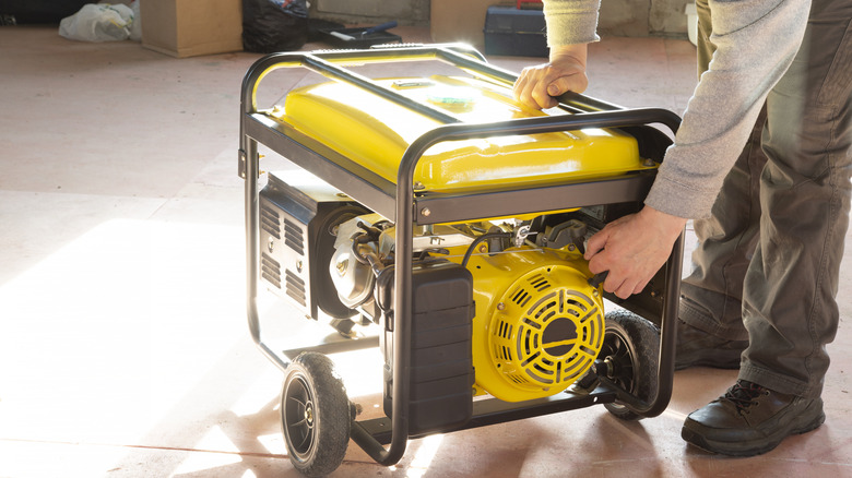 A person initiating a portable gas generator.